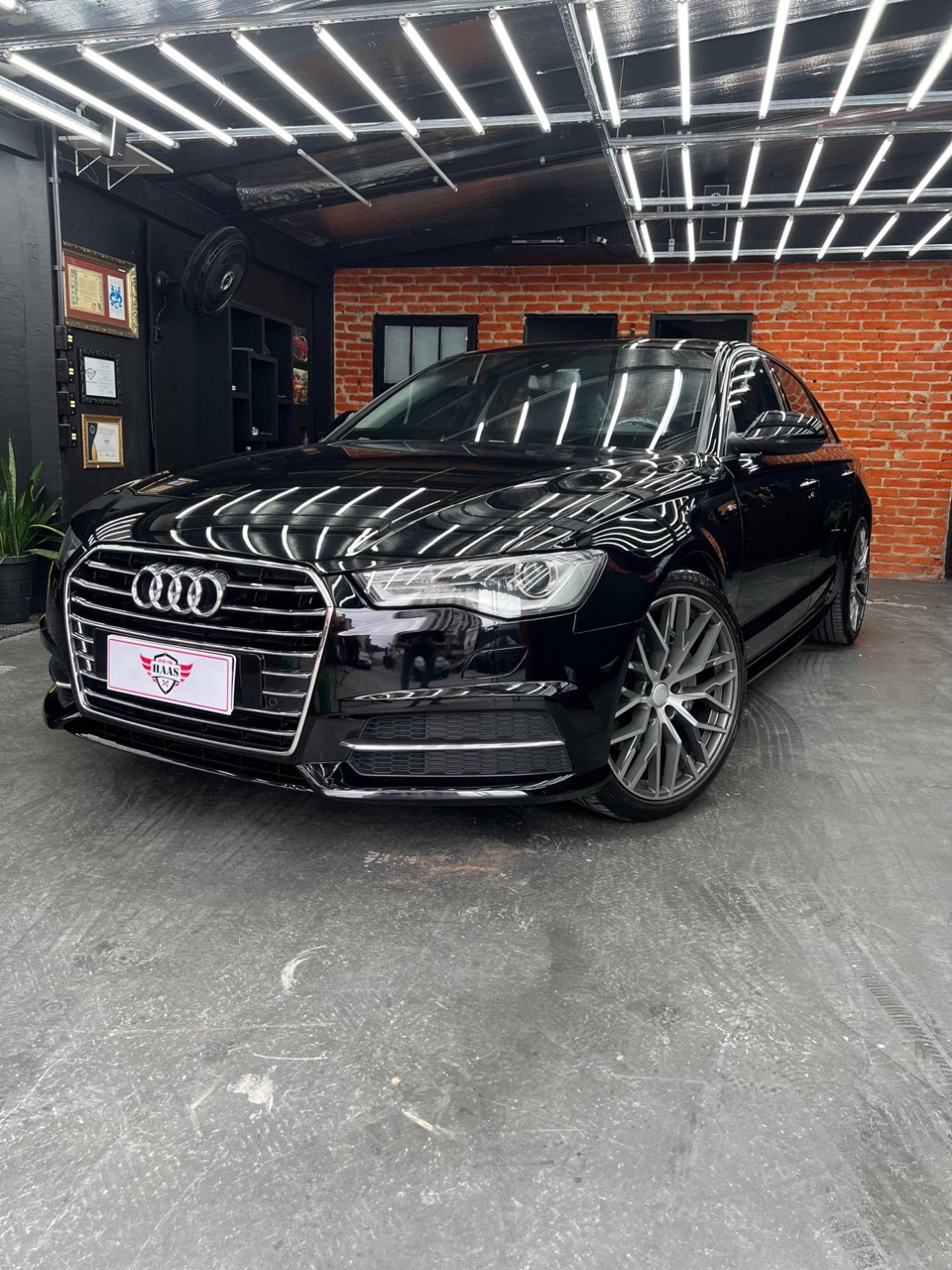 Audi A6 preto polido com reflexo das luzes
